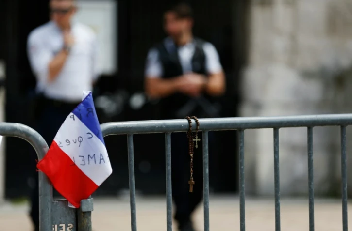 Drapeau tricolore et chapelet le 28 juillet 2016 devant l'église de Saint-Etienne-du-Rouvray, après l'assassinat du père Jacques Hamel, dont les agresseurs étaient fichés "S"  
