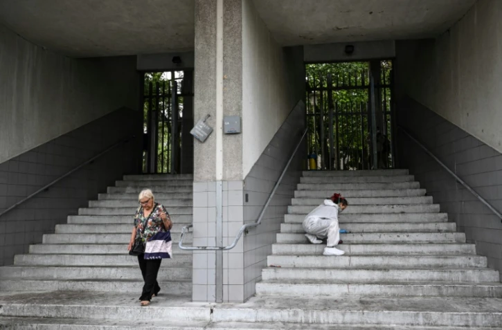 Un employé nettoye des traces de sang sur la scène du crime, où deux personnes ont été tuées, dans le quartier de La Duchère, à Lyon, le 15 juin 2022