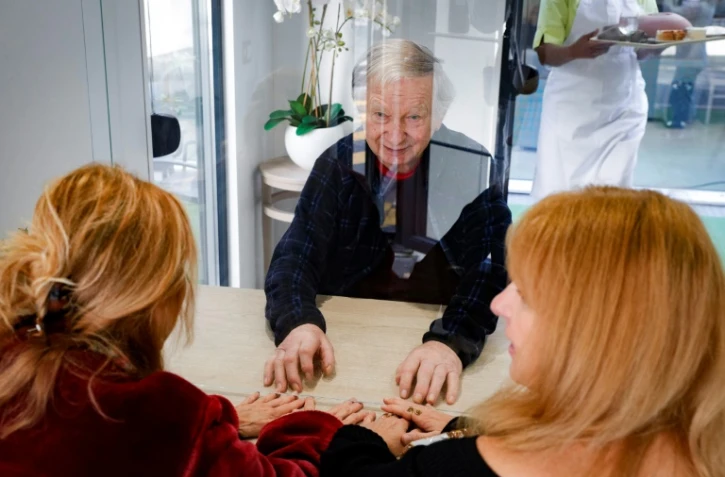 Guy, 93 ans, avec ses deux filles Elisabeth (d) et Véronique dans un mobile-home où ils peuvent déjeuner ensemble, le 12 novembre 2020 à l'Ehpad Beauregard, à Villeneuve-Saint-Georges, près de Paris