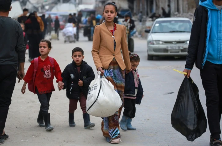 Des déplacés palestiniens transportant quelques affaires arrivent dans la ville de Gaza, après des ordres d'évacuation israéliens, le 11 avril 2025