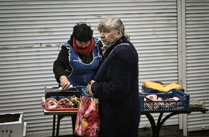 Une femme achète de la viande à Soledar, dans l'est de l'Ukraine le 28 mai 2022