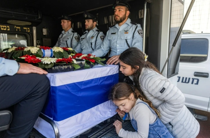 Des enfants se penchent sur le cercueil de Ran Gvili, lors de ses funérailles à Meitar, dans le sud d'Israël, le 28 janvier 2026