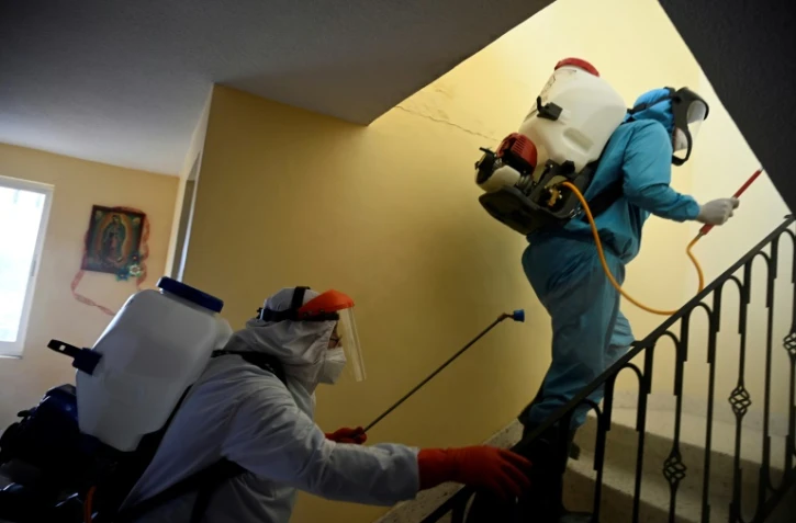 Par précaution contre le virus Covid-19, du personnel municipal désinfecte une habitation dans le quartier de Xochimilco à Mexico, le 26 août