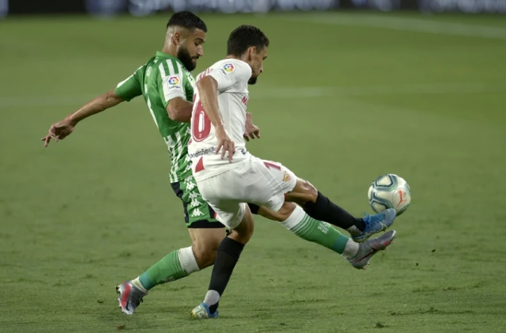 Le Français du Real Betis Nabil Fékir (g) à la lutte avec le milieu de Séville Jesus Navas, le 11 juin 2020 au stade Ramon Sanchez Pizjuan de Séville