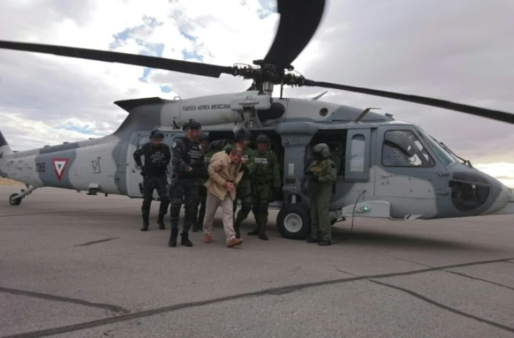 Photo fournie par le ministère mexicain de l'Intérieur de Joaquin Guzman Loera alias "El Chapo" Guzman escorté par la police le 20 janvier 2017 à Ciudd Juarez au Mexique