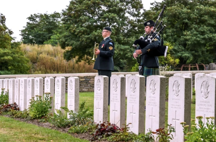 Un soldat canadien joue de la cornemuse pendant l'inhumation de quatre soldats canadiens tués pendant la Première Guerre Mondiale, à Loos-en-Gohelle, dans le nord de la France, le 23 août 2018