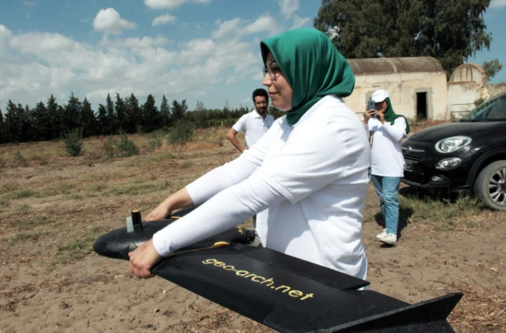 Imen Hibri, fondatrice de RoboCare, se prépare à faire voler un drone au-dessus d'un domaine agricole pour scanner les arbres et évaluer leur niveau d'hydratation ou la qualité du sol, le 30 août 2023 à Nabeul, au Maroc