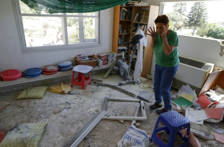 Une femme au milieu des dégâts provoqués par l'explosion d'une roquette tirée de la bande de Gaza et qui s'est abattue sur le village de Netiv Haasara en Israël, le 4 mai 2019