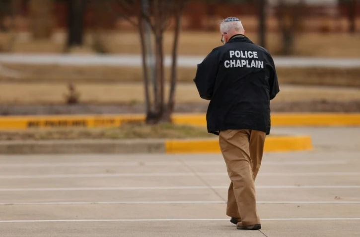 Un aumônier de la police sur un parking près de la synagogue Congregation Beth Israel à Colleyville, Texas, le 15 janvier 2022