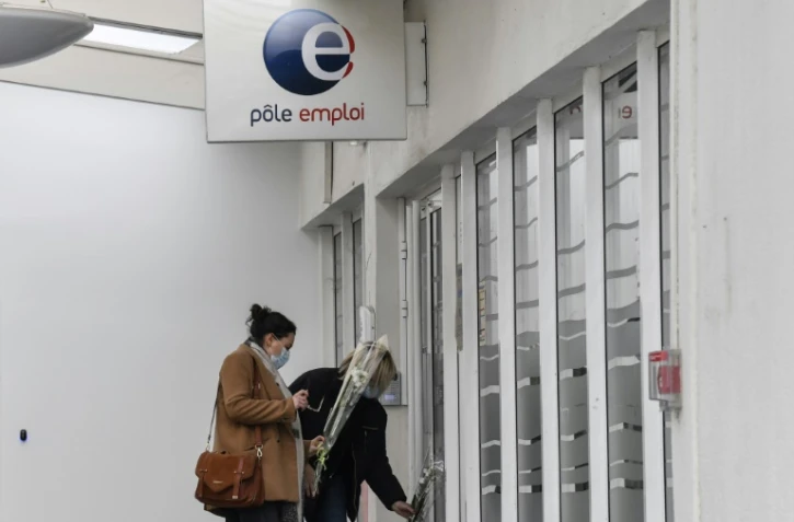 Deux femmes déposent des fleurs, le 29 janvier 2021, devant l'agence Pôle Emploi de Valence, où une conseillère a été tuée la veille.