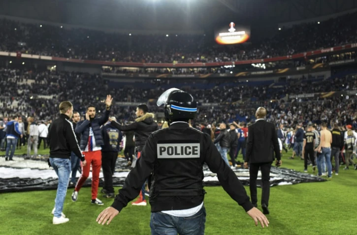 Des supporters lyonnais du Virage Sud envahissent la pelouse pour échapper à des jets de projectiles de supporters turcs, le 13 avril 2017 au Parc OL