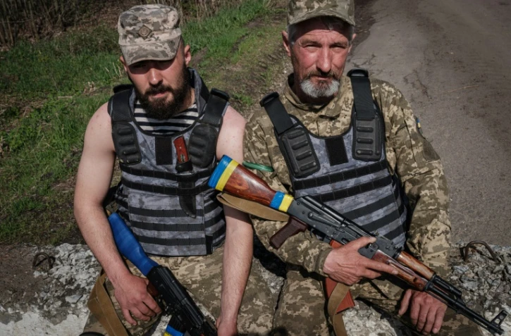 Un père et son fils, membres des forces ukrainiennes, à un poste de contrôle près de Barvinkove, dans l'est de l'Ukraine, le 25 avril 2022