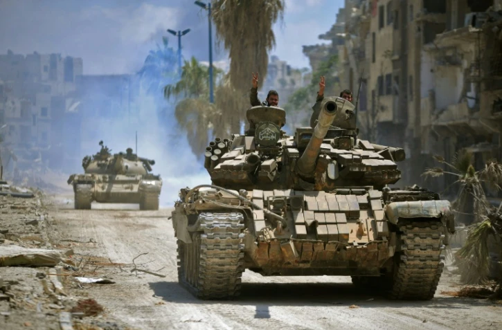 Des combattants gouvernementaux progressent en direction de positions du groupe jihadiste Etat islamique (EI) dans le quartier de Hajar al-Aswad dans le sud de Damas. Photo fournie par l'agence officielle syrienne SANA, le 14 mai 2018