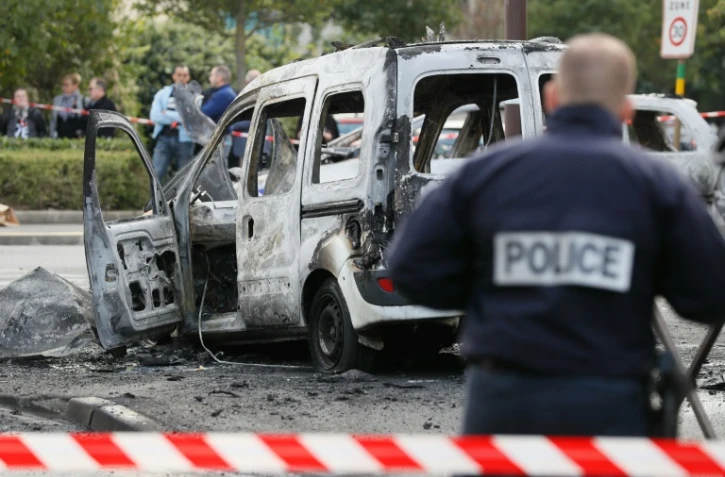 Un policier devant la carcasse d'un véhicule de police incendié à Viry-Chatillon le 8 octobre 2016