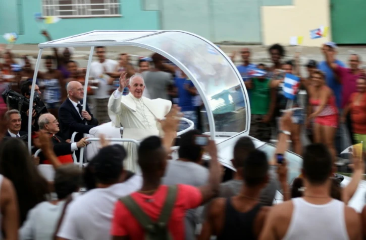 Le pape François salue la foule  sur la route entre l'aéroport Jose Marti et le centre de La Havane, le 19 septembre 2015