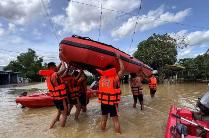 Des secouristes transportent des bateaux pneumatiques pour évacuer des habitants près de Tuguegarao, au nord de Manille, alors que les eaux de crue continuent d'inonder les maisons en raison des fortes pluies provoquées par le super typhon Fung-wong, le 11 novembre 2025 aux Philippines