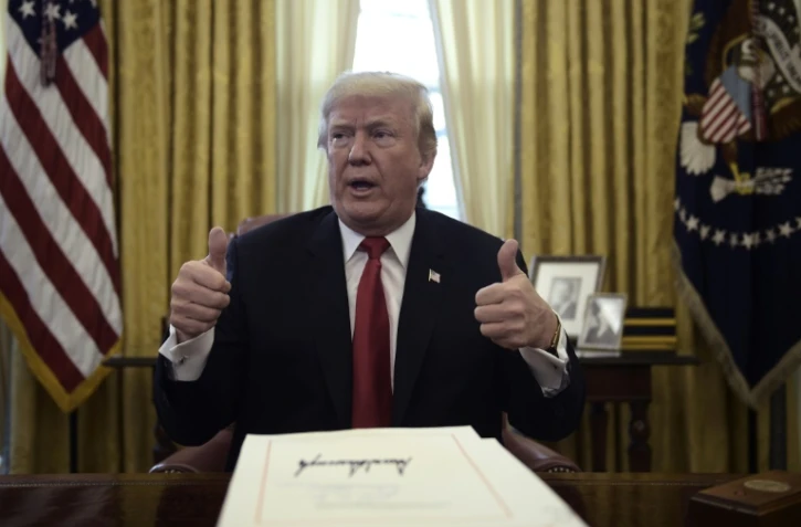 Le président américain Donald Trump promulgue la baisse d'impôts dans le bureau ovale de la Maison Blanche à Washington, le 22 décembre 2017