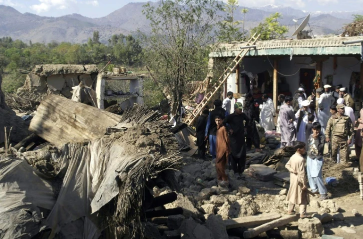 Des policiers et habitants au milieu des ruines de maisons détruites par un puissant séisme, le 27 octobre 2015 à Lower Dir, au Pakistan