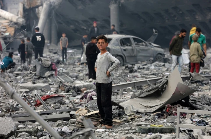 Un jeune garçon au milieu des décombres dans la cour d'une école où sont réfugiés des déplacés, touchée par une frappe israélienne la veille à Gaza-ville, le 4 avril 2025