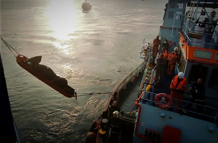 Les pompiers grecs transbordent le 20 février 2022 le corps d'un routier grec, retrouvé dans le ferry Euroferry Olympia, en feu au large de l'île de Corfou, en Grèce