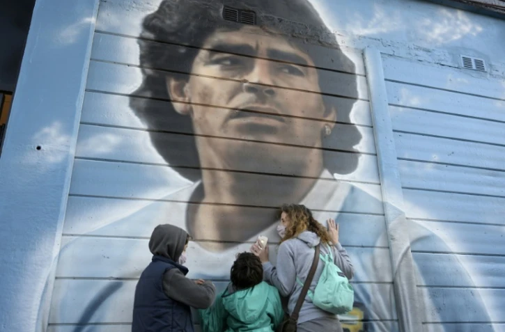 Des personnes se recueillent devant une fresque murale de Diego Maradona, peinte par l'artiste Marley, le 22 juin 2021 à Buenos Aires