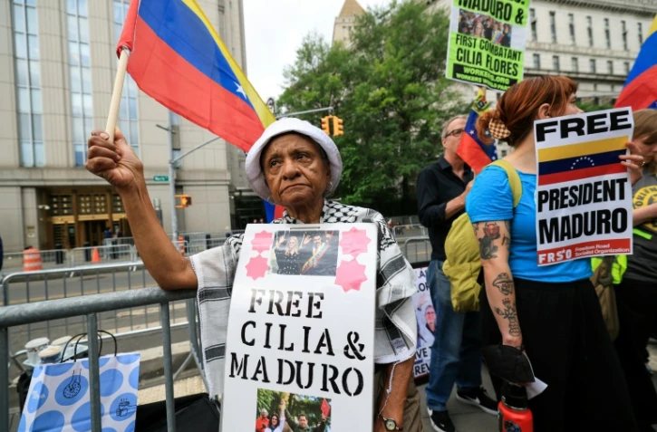 Des manifestants brandissent des pancartes en soutien à Nicolas Maduro et à son épouse Cilia Flores, à l'extérieur d'un tribunal de New York où le président vénézuélien déchu doit comparaître, le 22 juillet 2026 