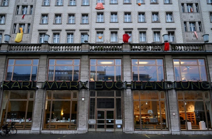 La devanture de la "Librairie Karl Marx" le 4 janvier 2019 dans la Karl-Marx-Allee à Berlin, surplombée par des banderoles de locataires protestant contre la vente de leur logement dans l'immeuble