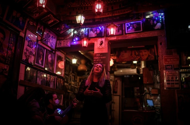 La chanteuse Claudia Picado (d), les guitaristes Pedro Dias (g) et Carlos Vicoso (c) Ă la maison de fado "Tasca do Chico", dans le quartier du Bairro Alto, le 12 novembre 2020 Ă Lisbonne