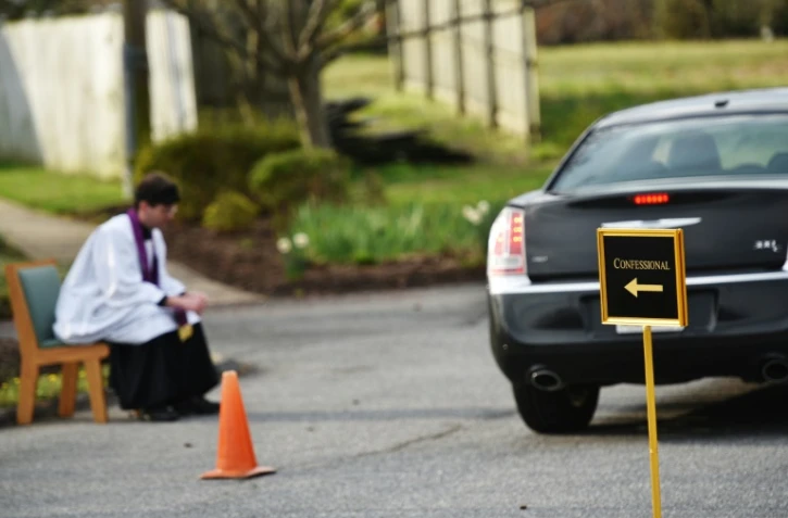 Le père Scott Holmer sur le parking d'une église à Bowie (Maryland, nord-est) le 20 mars 2020
