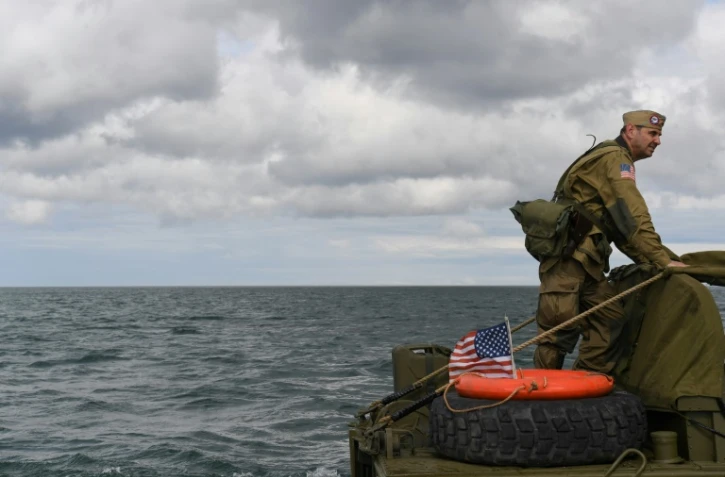 Un homme habillé en GI sur une reproduction de véhicule amphibie américain CCKW, utilisé pendant le Débarquement, à Arromanches (France) le 4 juin 2019