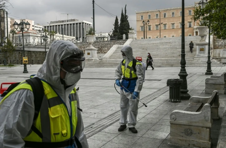 Des agents de la municipalité désinfectent la place Syntagma à Athènes, le 23 mars 2020