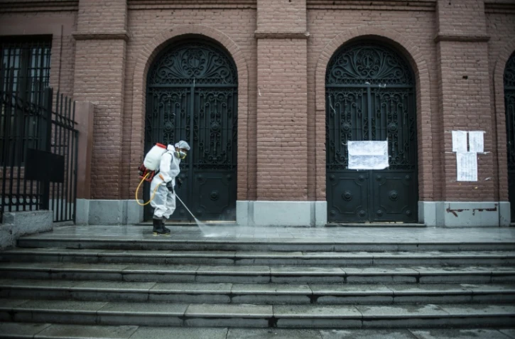 Un employé désinfecte les abords d'un bureau de vote à la veille du premier tour des élections présidentielles et législatives, à Lima le 10 avril 2021