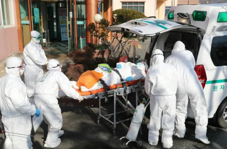 Le personnel médical transfère un patient soupçonné d'être porteur du coronavirus de l'hôpital Daenam à Cheongdo le 21 février 2020