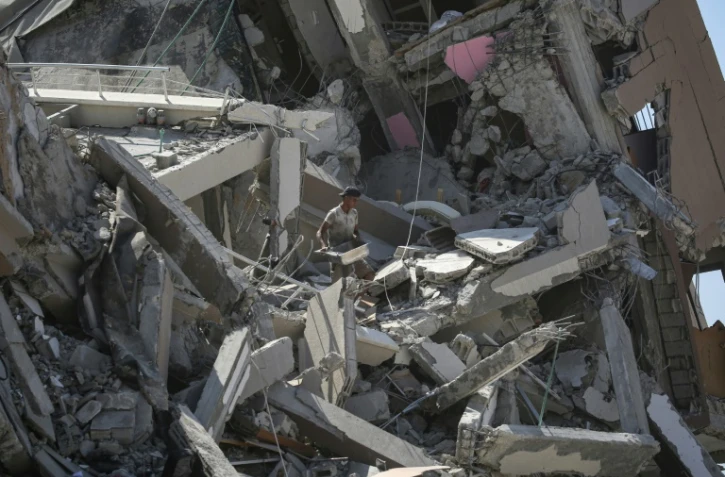 Un Palestinien tente de récupérer quelques affaires au milieu des décombres dans un secteur de Deir al Balah dont l'armée israélienne s'est retirée, le 29 août 2024