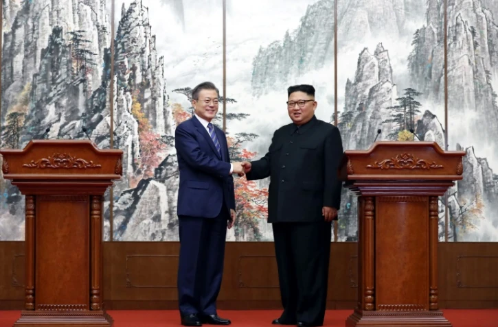 Le président sud-coréen Moon Jae-in (g) et le président nord-coréen Kim Jong Un à l'issue d'une conférence de presse commune après le sommet inter-coréen de Pyongyang, le 19 septembre 2018