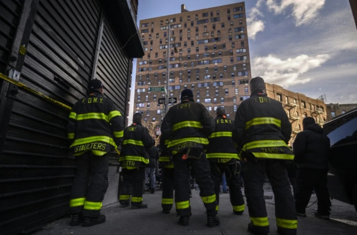 Des pompiers devant l'immeuble qui a pris feu dans le quarteir du Bronx à New York, le 10 janvier 2022