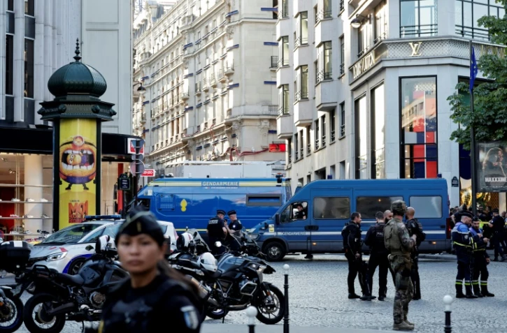 Des policiers, des gendarmes et un soldat sécurisent la zone devant une boutique Louis Vuitton après qu'un homme ait attaqué un policier avec un couteau, sur les Champs-Elysées, à Paris, le 18 juillet 2024.