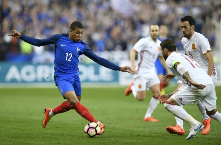 Le jeune attaquant des Bleus Kylian Mbappé défie l'arrière garde espagnole en match amical au stade de France, le 28 mars 2017