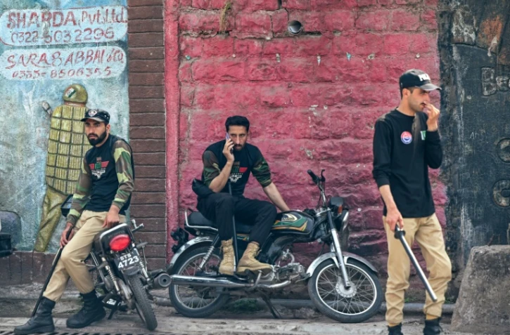 Des policiers montent la garde le long d'une route à Muzaffarabad, le 5 mai 2025 au Cachemire pakistanais
