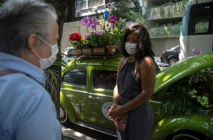 Roberta Machado (D) parle avec un client le 14 octobre 2020 à Rio de Janeiro (Brésil)