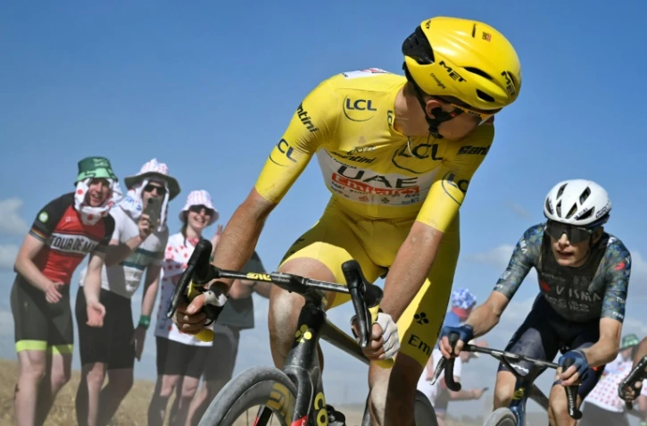 Le Slovène de l'équipe UAE Tadej Pogacar, porteur du maillot jaune, regarde derrière lui le Danois de la formation Visma Jonas Vingegaard, son principal rival dans le Tour de France, lors de la 9e étape autour de Troyes en France, le 7 juillet 2024