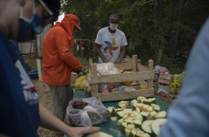 Le détenu Eliseu dos Santos (c) participe à une distribution de nourriture pour les animaux près de la route Transpantaneira, le 19 septembre 2020 dans le Pantanal brésilien ravagé par les incendies