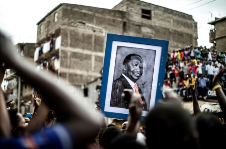 Des opposants au président kényan Uhuru Kenyatta brandissent le portrait du leader de l'opposition Raila Odinga lors d'une manifestation à Nairobi, le 13 août 2017