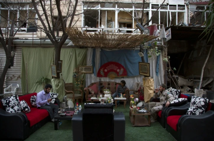 Des rebelles syriens consultent leurs messages et dialoguent avec leur famille à l'occasion de la trêve, le 2 mars 2016 à Alep