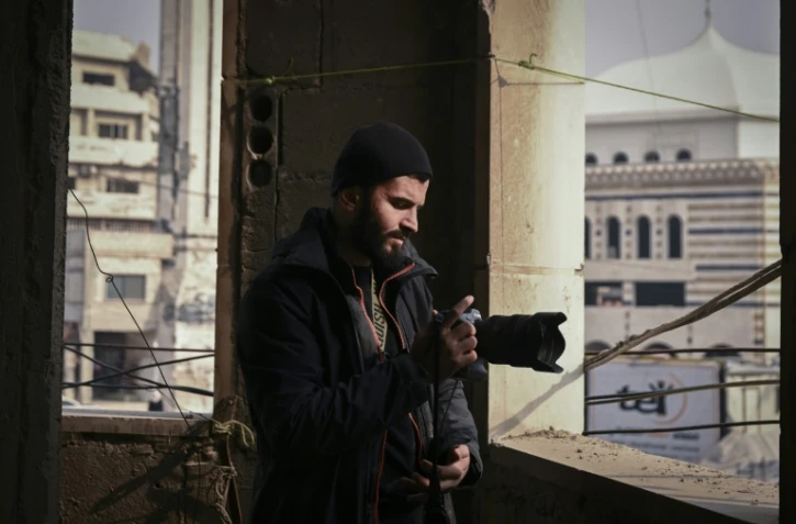 Le photographe syrien Sameer al-Doumy dans un immeuble endommagé à Douma, près de Damas, le 22 décembre 2024