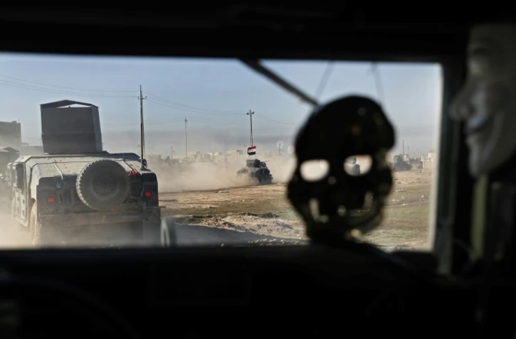 Un masque de crâne et un masque des Anonymous pendent à l'intérieur d'un véhicule blindé des Forces spéciales irakiennes, le 24 novembre 2016 au nord-est de Mossoul