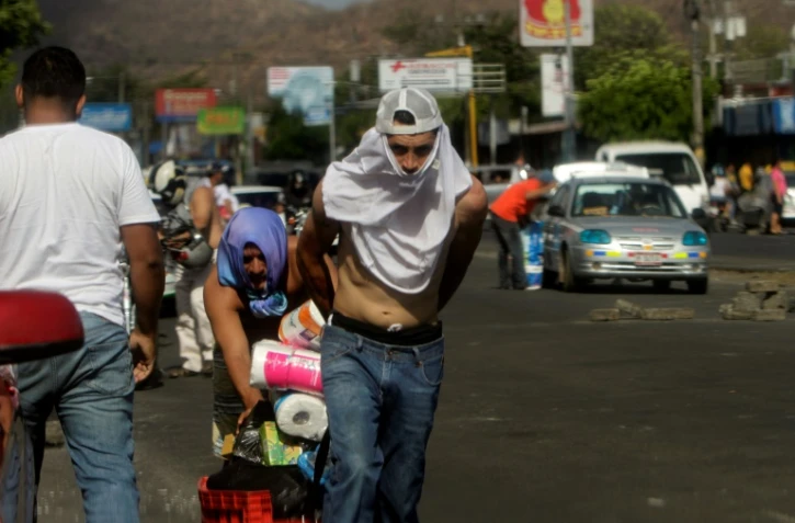 Deux pillards s'enfuient d'un supermarché à Managua, le 22 avril 2018