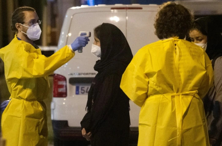 Des soignants accueillent les Afghans rapatriés en Espagne à l'aéroport de Torrejon de Ardoz, près de Madrid le 19 août 2021