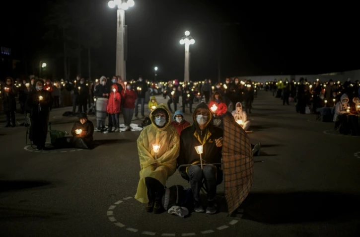 Des fidèles regroupés dans des cercles distanciés tracés au sol pour le pèlerinage à Fatima au Portugal le 12 mai 2021