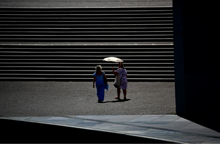 Des passantes se protègent du soleil sous une ombrelle à Berlin, pendant une vague de chlauer, le 26 juin 2026